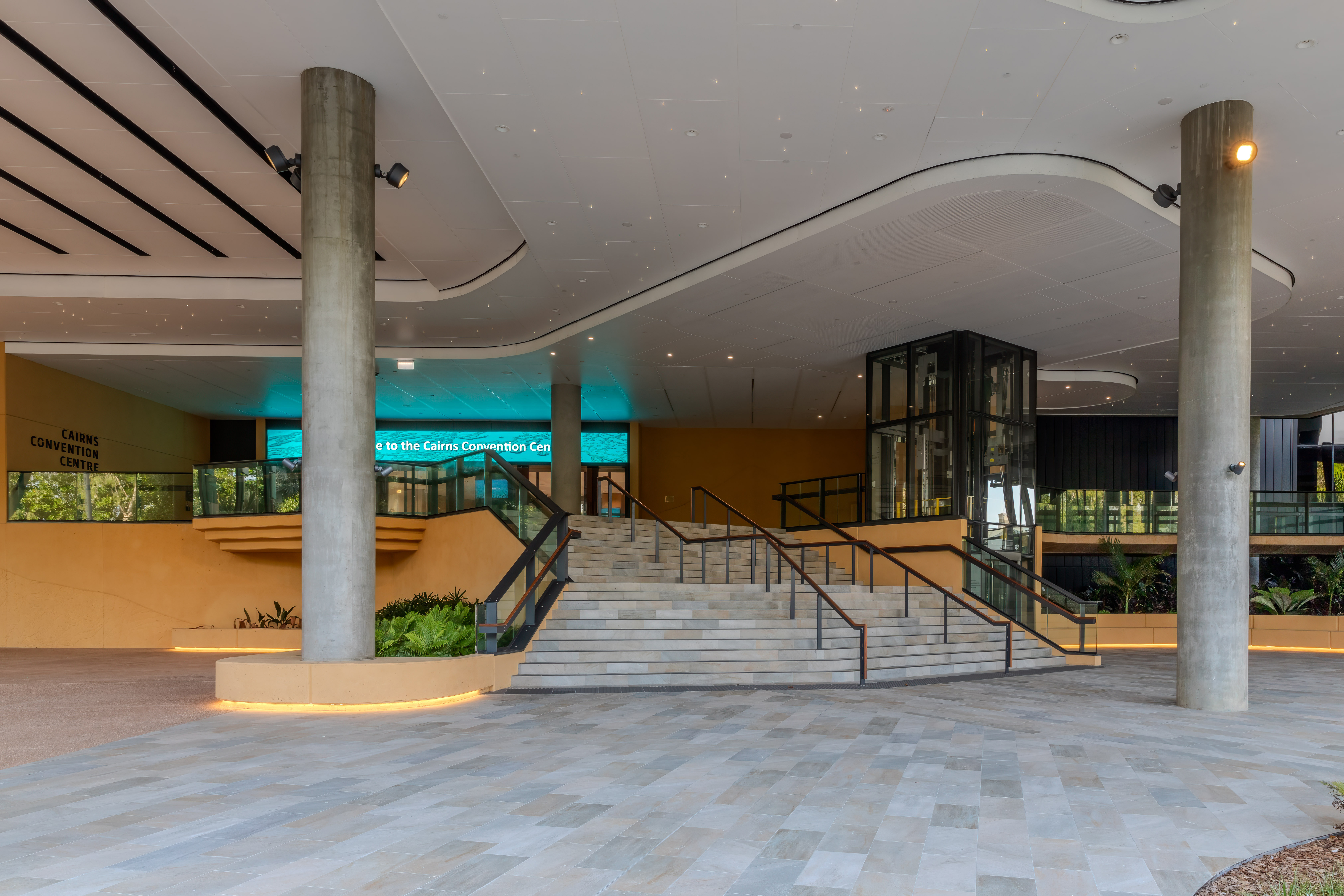 Entrance to the Cairns Convention Centre including stairs and lift. A large electronic, digital sign welcome guests.